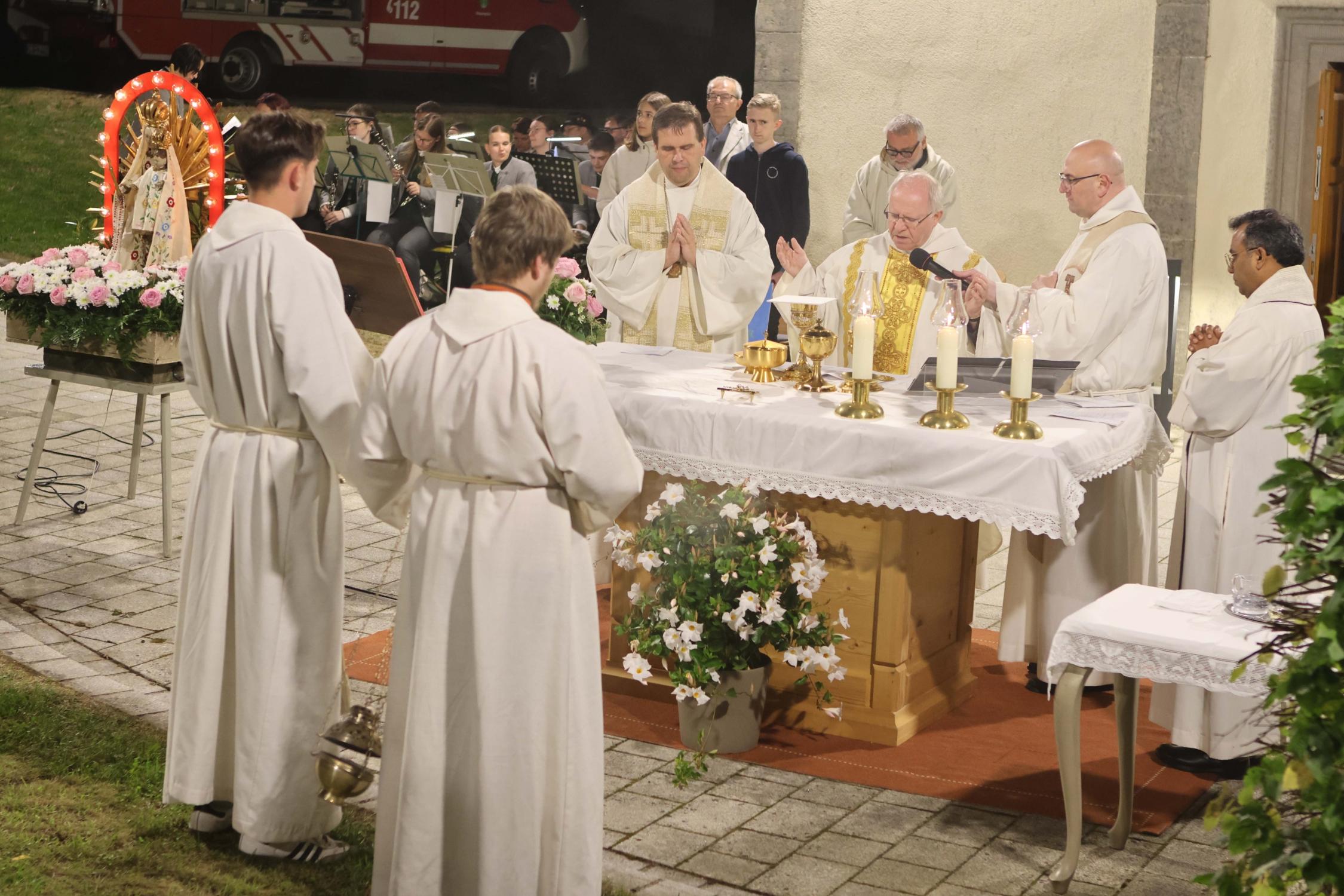 Die Zelebranten Domkapitular Martin Emge, Dekan Detlef Pötzl und die Priester Sven Raube und Cyriac Chittukalam am Altar vor dem Gotteshaus, links die Firmlinge mit Pastoralreferent Harald Ulbrich