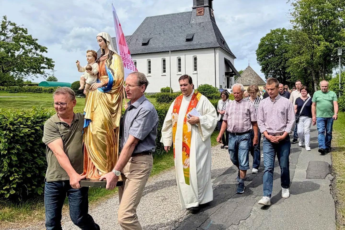 Prozession mit der Marienfigur von der Kirche in den Pfarrsaal.