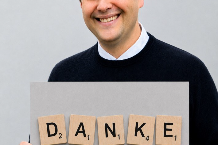 Pfarrer Detlef Pötzl hält ein Schild mit der Aufschrift Danke in den Händen.