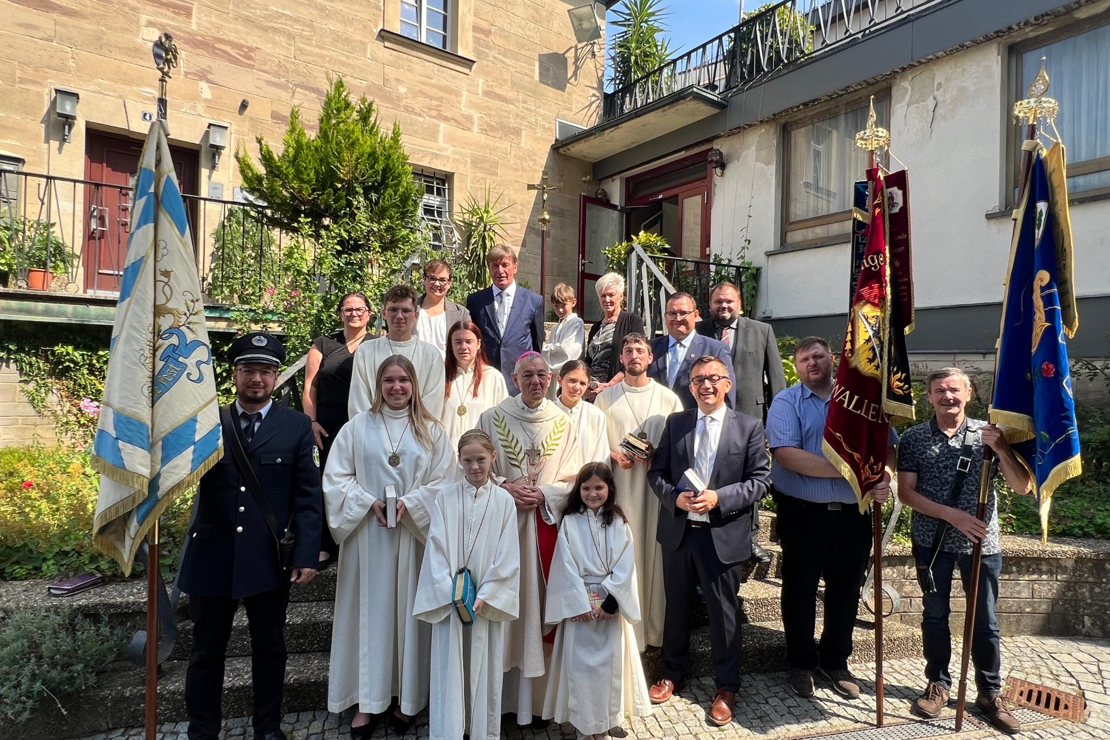 Gruppenbild mit Erzbischof em. Ludwig Schick, Bürgermeister Jens Korn, dem Liturgischen Dienst und den Fahnenabordnungen der Vereine