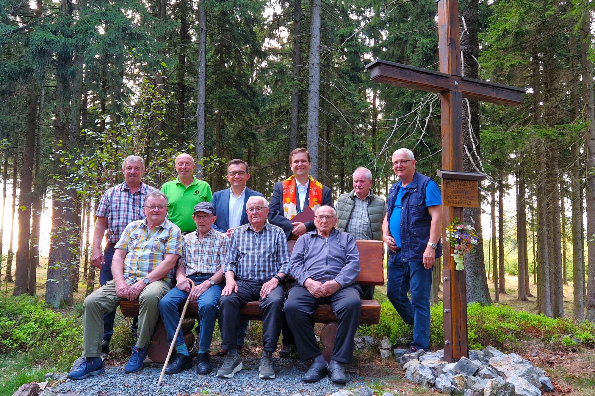 Dekan Detlef Pötzl segnete das restaurierte Gipfelkreuz. Auf der Bank von rechts die noch lebenden Bergfreunde Andreas „Siegmund“ Müller und Franz Schlee, sowie die Helfer und Bürgermeister Jens Korn (hinten 3.v.li)