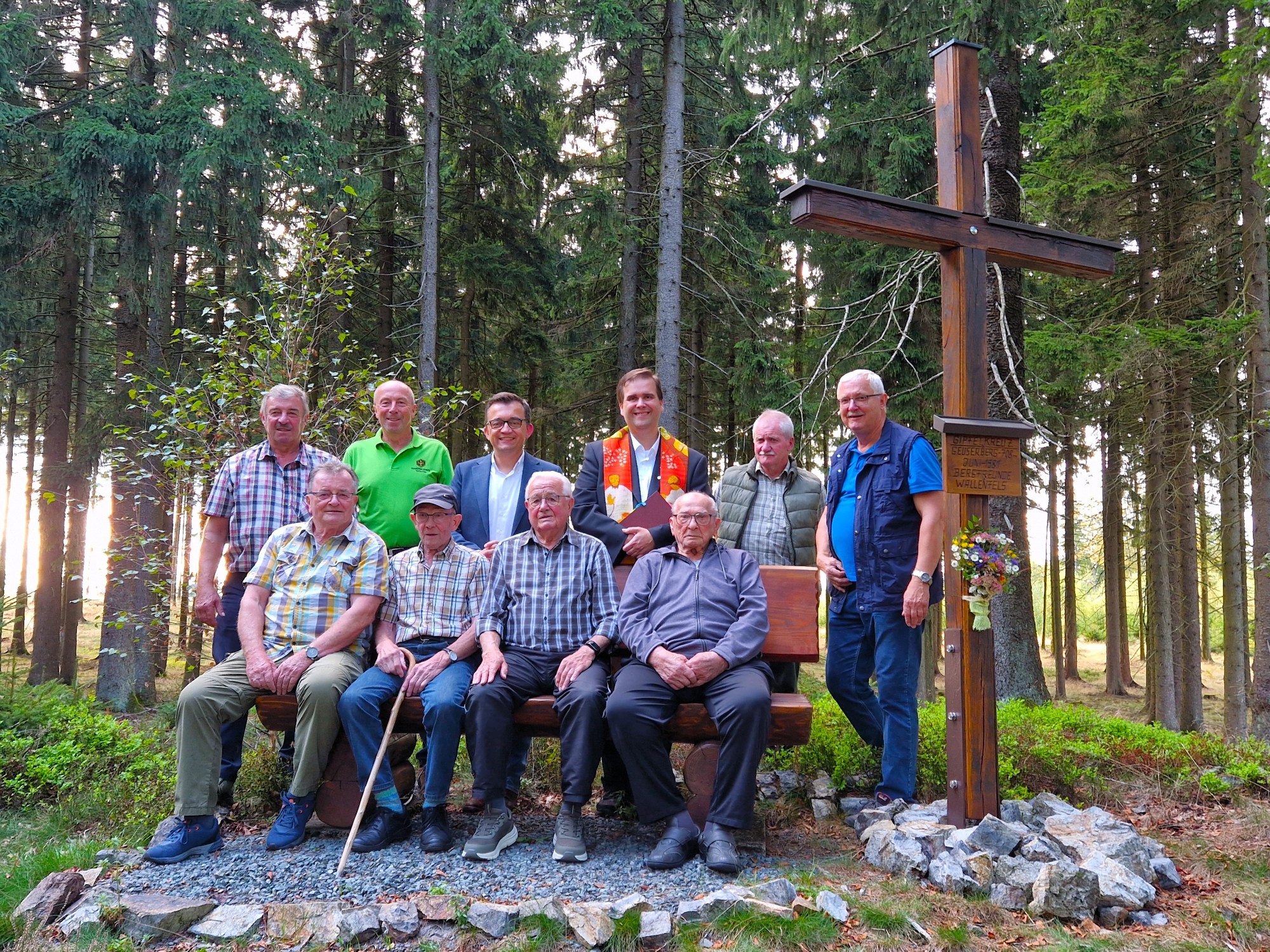Dekan Detlef Pötzl segnete das restaurierte Gipfelkreuz. Auf der Bank von rechts die noch lebenden Bergfreunde Andreas „Siegmund“ Müller und Franz Schlee, sowie die Helfer und Bürgermeister Jens Korn (hinten 3.v.li)
